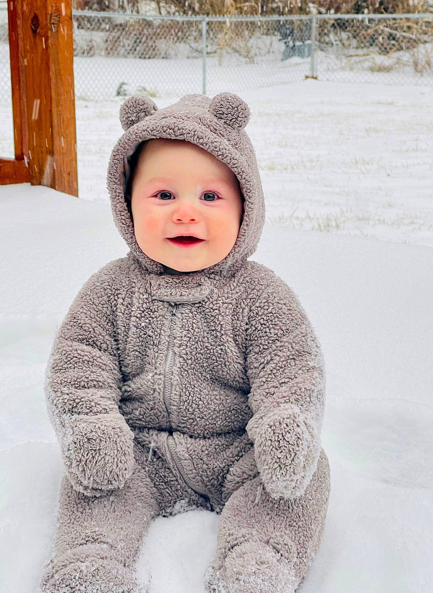 Israel is registered to the contest to win money with this photo: baby, baby_toddler_clothing, cap, cheek, child, clothing, face, facial_expression, fence, freezing, happy, head, headgear, headwear, pattern, person, skin, sleeve, smile, snow
