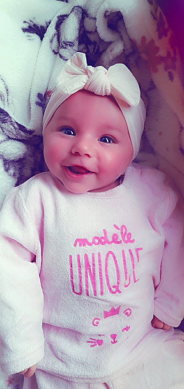 Sounai participe au concours pour gagner de l'argent avec cette photo : baby, baby_toddler_clothing, cap, cheek, eyebrow, face, happy, head, headgear, headwear, iris, lip, magenta, outerwear, person, pink, skin, sleeve, smile, textile