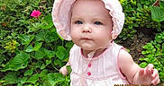 Kiriana is registered to the contest to win money with this photo: baby, child, pink_bonnet, pink_dress, flowers, greenery, plants, outdoor, nature, garden, cute, portrait, infant, face, headwear, summer, sunlight, young_child, skin, expression