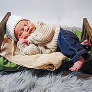 Josephine joined the competition — help win amazing prizes! baby, newborn, infant, sleeping, knit_hat, knit_sweater, denim_jeans, wooden_bed, beige_blanket, green_pillow, faux_fur_rug, tiny_feet, tiny_hands, cozy, studio_photography, props, peaceful, portrait, newborn_photography, soft_texture