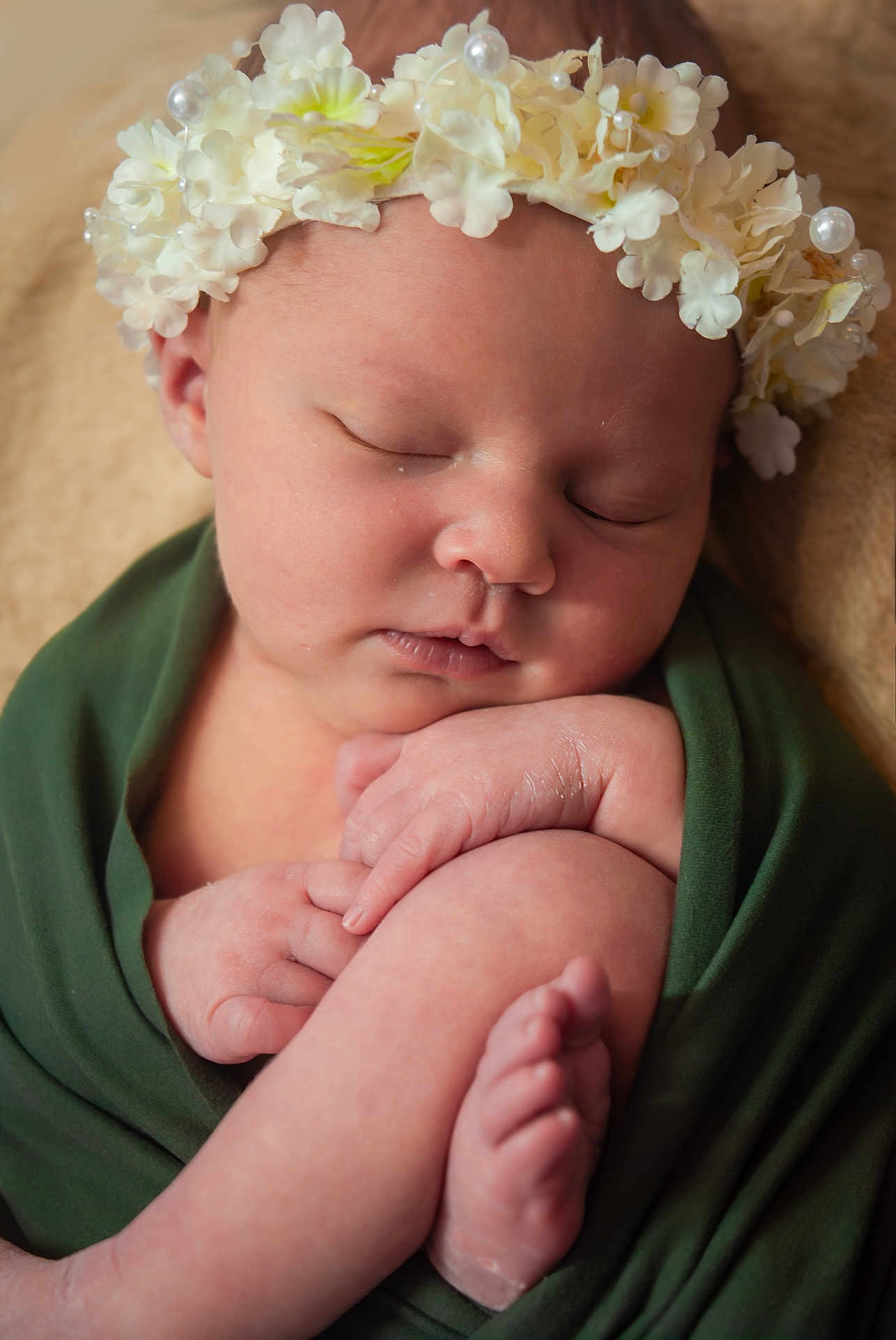 Josephine is registered to the contest to win money with this photo: baby, newborn, flower_crown, sleeping, swaddle, portrait, closeup, infant, peaceful, soft_texture, green_cloth, hands, feet, skin, cute, headband, flowers, blanket, studio, peaceful_sleep