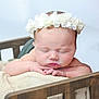 baby, newborn, sleeping, flower_crown, headband, crib, blanket, wooden_bed, infant, hands, portrait, closeup, soft_light, peaceful, cute, studio_shot, skin, cozy, nursery, delicate