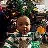 Victor is registered to the contest to win money with this photo: baby, child, reindeer_antlers, christmas_tree, holiday, gift, toy, pajamas, festive, indoors, decorations, christmas_lights, carpet, face, smiling, cute, holiday_season, celebration, sitting, present