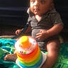 Victor joined the competition — help win amazing prizes! baby, infant, child, towel, toy, stacking_toy, colorful, rainbow, sitting, indoors, couch, clothing, shortsleeve, foot, hand, face, expression, play, soft_light, background
