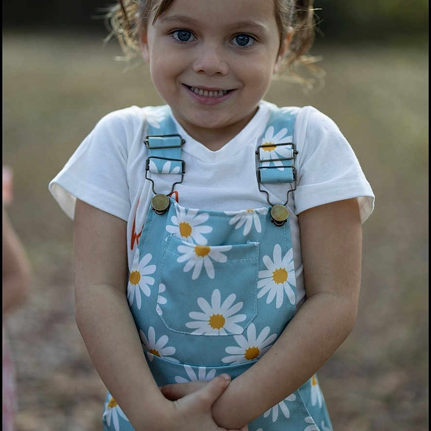 Charlee is registered to the contest to win money with this photo: child, girl, smile, pigtails, outdoor, field, nature, daisy, floral, clothing, portrait, happy, standing, cute, young, sunlight, daylight, person, casual, fashion