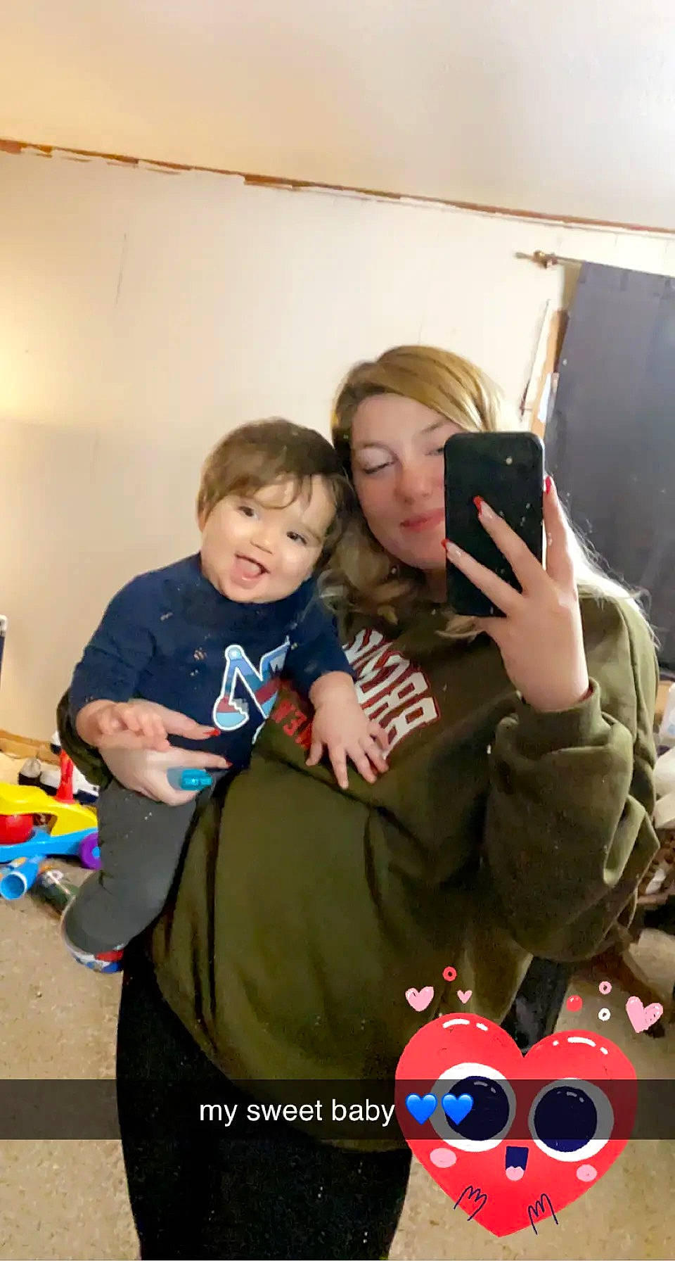 Kobi is registered to the contest to win money with this photo: baby, child, event, facial_expression, fun, gadget, gesture, happy, holiday, interaction, mobile_phone, person, play, portable_communications_device, room, selfie, sitting, sleeve, standing, t_shirt