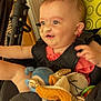 baby, child, stroller, toy, pacifier, nasal_tube, smiling, yellow, pattern, clothing, seatbelt, indoor, cute, infant, plush_toy, happy, person, face, hair, comfort