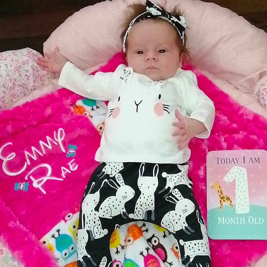 Emmy is registered to the contest to win money with this photo: baby, baby_products, baby_toddler_clothing, bedding, child, linens, nap_mat, person, pink, product, smile, textile, toddler