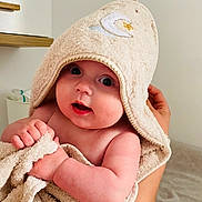 Lina participe au concours pour gagner de l'argent avec cette photo : arm, baby, blanket, child, cozy, curious, cute, expression, face, hand, holding, hood, indoor, infant, newborn, person, skin, soft, towel, wrapped