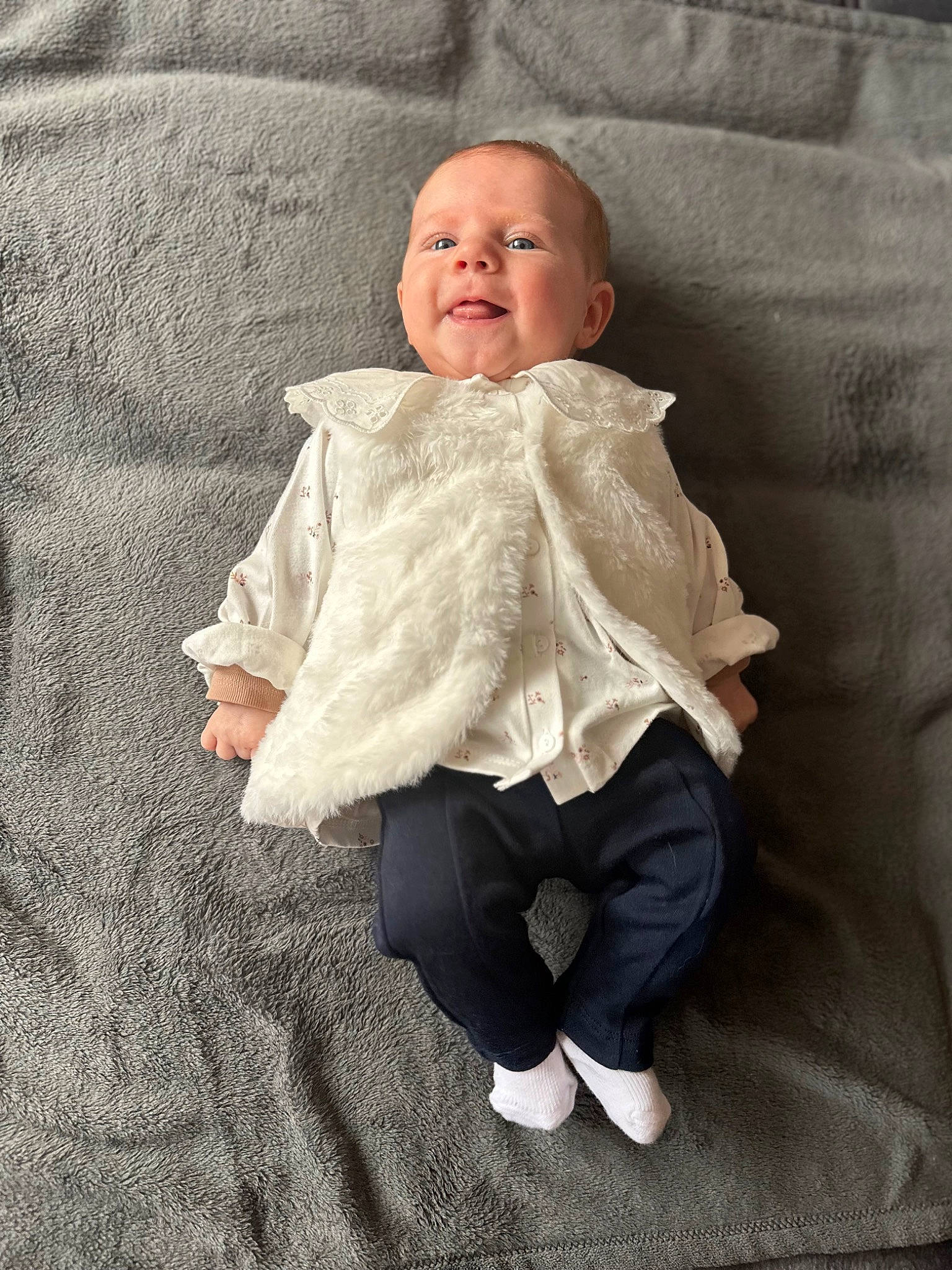 Alma participe au concours pour gagner de l'argent avec cette photo : baby, baby_toddler_clothing, cheek, child, comfort, flooring, fur, grey, knitting, linens, pattern, person, room, sitting, skin, sleeve, smile, textile, toddler, wood