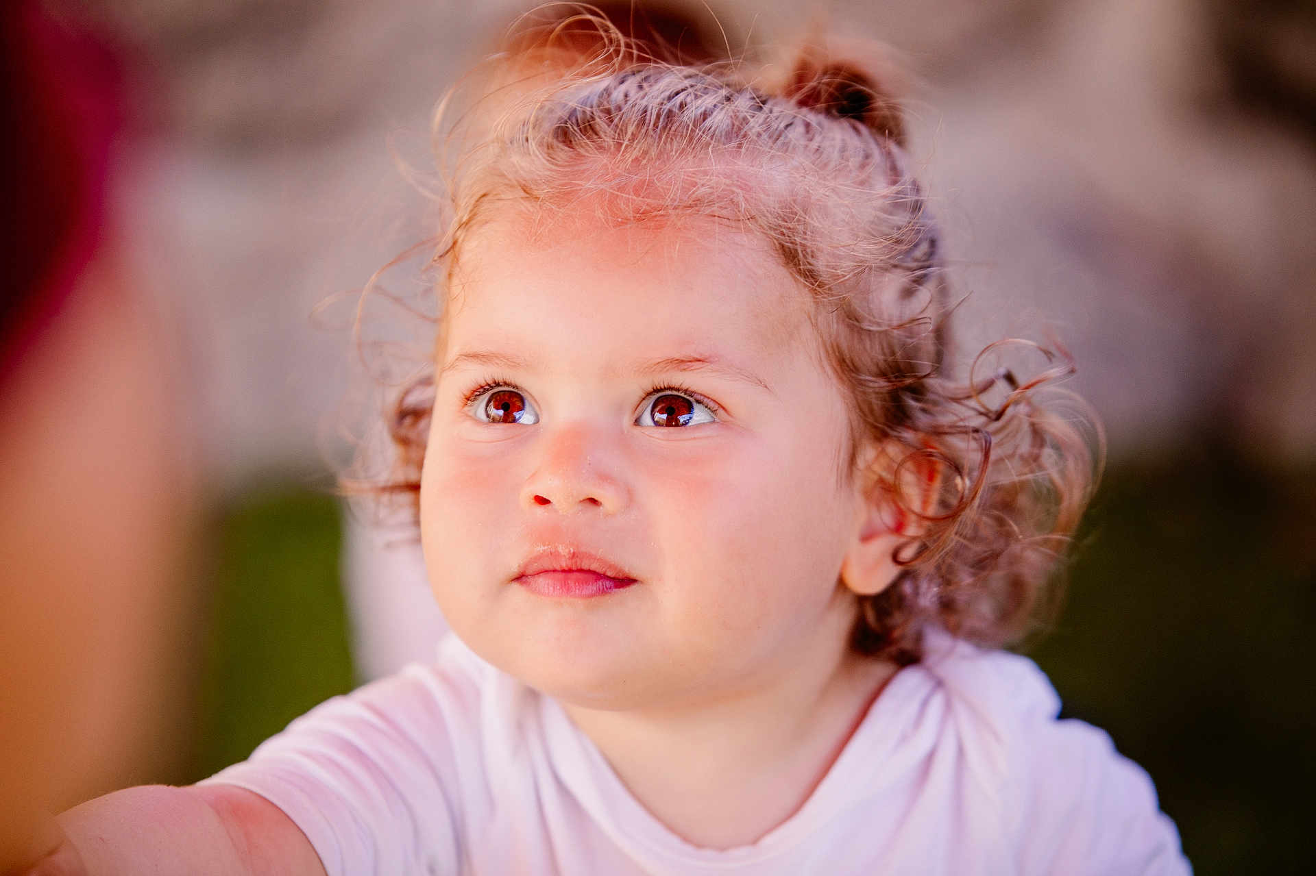 Sahel participe au concours pour gagner de l'argent avec cette photo : child, toddler, curly_hair, face, portrait, expressive_eyes, close_up, natural_light, outdoor, soft_background, innocence, young_child, cute, curly_hair_toddler, white_shirt, skin, person, baby, looking_up, daylight