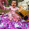 toddler, child, balloon, pink_pajamas, blanket, hello_kitty, outdoor, grass, backyard, house, fence, toy, curly_hair, expression, sitting, playful, colorful, foot, person, celebration