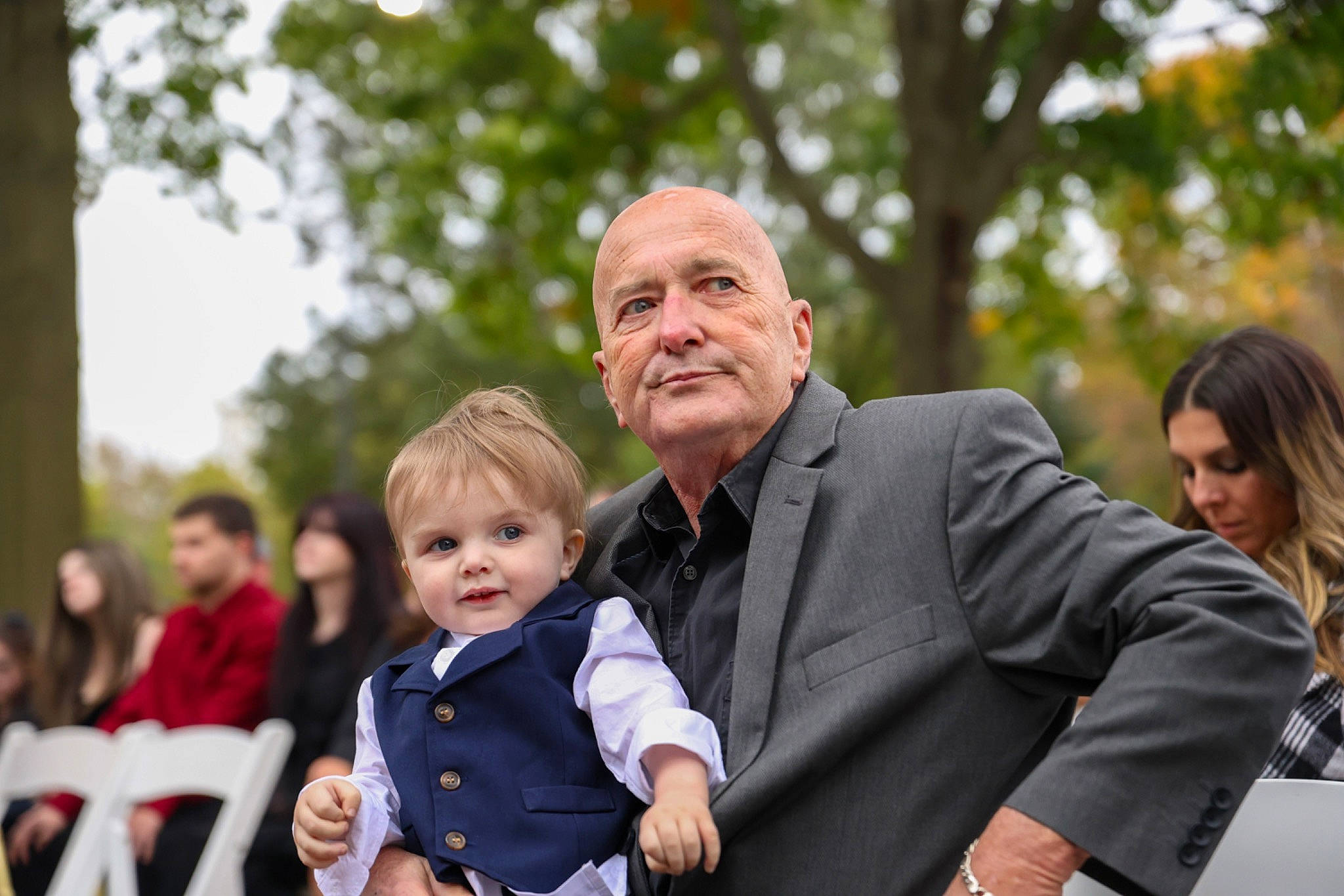 Lachlan joined the competition — help win amazing prizes! baby, blurred, ceremony, event, facial_expression, family_pictures, formal_wear, fun, gesture, grass, happy, interaction, joy, leisure, people_in_nature, person, recreation, sitting, sky, smile