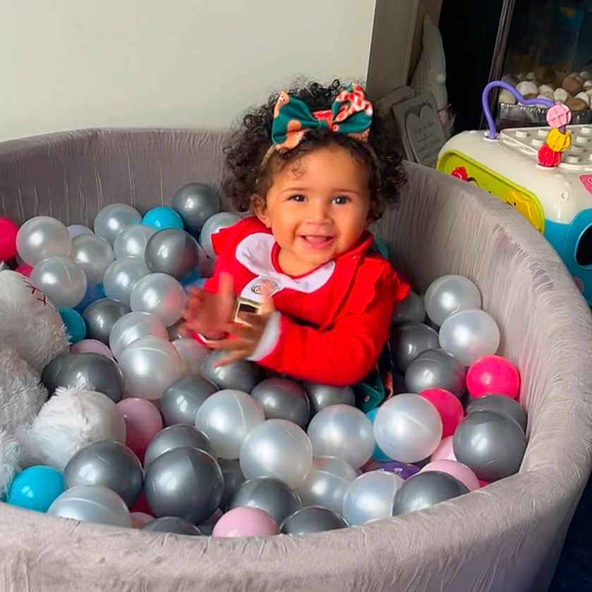Levaeh is registered to the contest to win money with this photo: accessories, baby, ball, balloon, clothing, costume, couch, dress, face, football, furniture, happy, head, jewelry, person, photography, portrait, sitting, smile, soccer