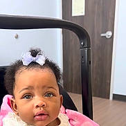 Kenzlii joined the competition — help win amazing prizes! baby, child, infant, bow, curly_hair, stroller, pink_blanket, indoor, door, wooden_door, face, portrait, cute, adorable, expression, clothing, person, head, eyes, mouth