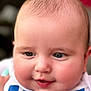 baby, close_up, face, infant, child, cute, chubby_cheeks, smiling, blue_clothing, white_clothing, portrait, skin, head, baby_face, eyes, mouth, soft_lighting, indoor, human, person
