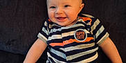 Oden is registered to the contest to win money with this photo: baby, baby_boy, baby_girl, child, couch, cute, expression, face, hand, happy, head, indoor, infant, legs, onesie, portrait, sitting, skin, smiling, striped_clothing