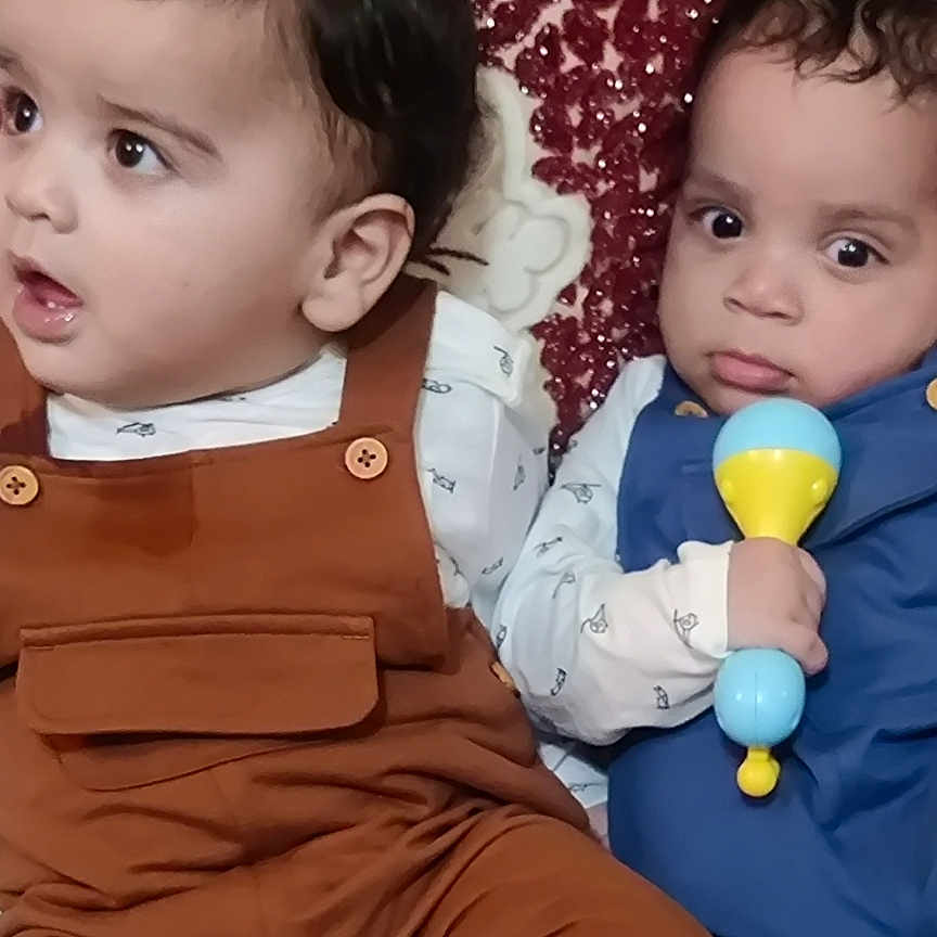 Ibrahim Et Salman participe au concours pour gagner de l'argent avec cette photo : babies, baby, blanket, child, closeup, clothing, curly_hair, cushion, cute, expression, face, indoor, infant, overalls, patterned, person, rattle, sitting, toy, young_child