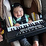 baby, car_seat, child, clothing, cushion, feet, footwear, hands, happy, indoor, infant, keyboard, music, pacifier, plush_toy, portrait, seat_belt, small_keyboard, smiling, toy