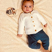 Lorenzo a rejoint le concours — aidez-le/la à gagner de superbes lots ! baby, blanket, blue_pants, child, cozy, curious_expression, cute, giraffe, indoors, infant, knitwear, lying_down, months_marker, portrait, small_hands, socks, soft_texture, warm_colors, white_sweater, wooden_sign