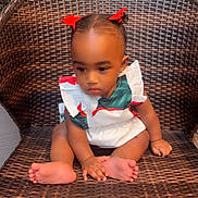 Brielle is registered to the contest to win money with this photo: toddler, child, baby, sitting, wicker_chair, red_bows, hair_accessories, barefoot, hands, feet, white_dress, patterned_clothing, brick_wall, outdoor, portrait, cute, young_child, person, expression, furniture