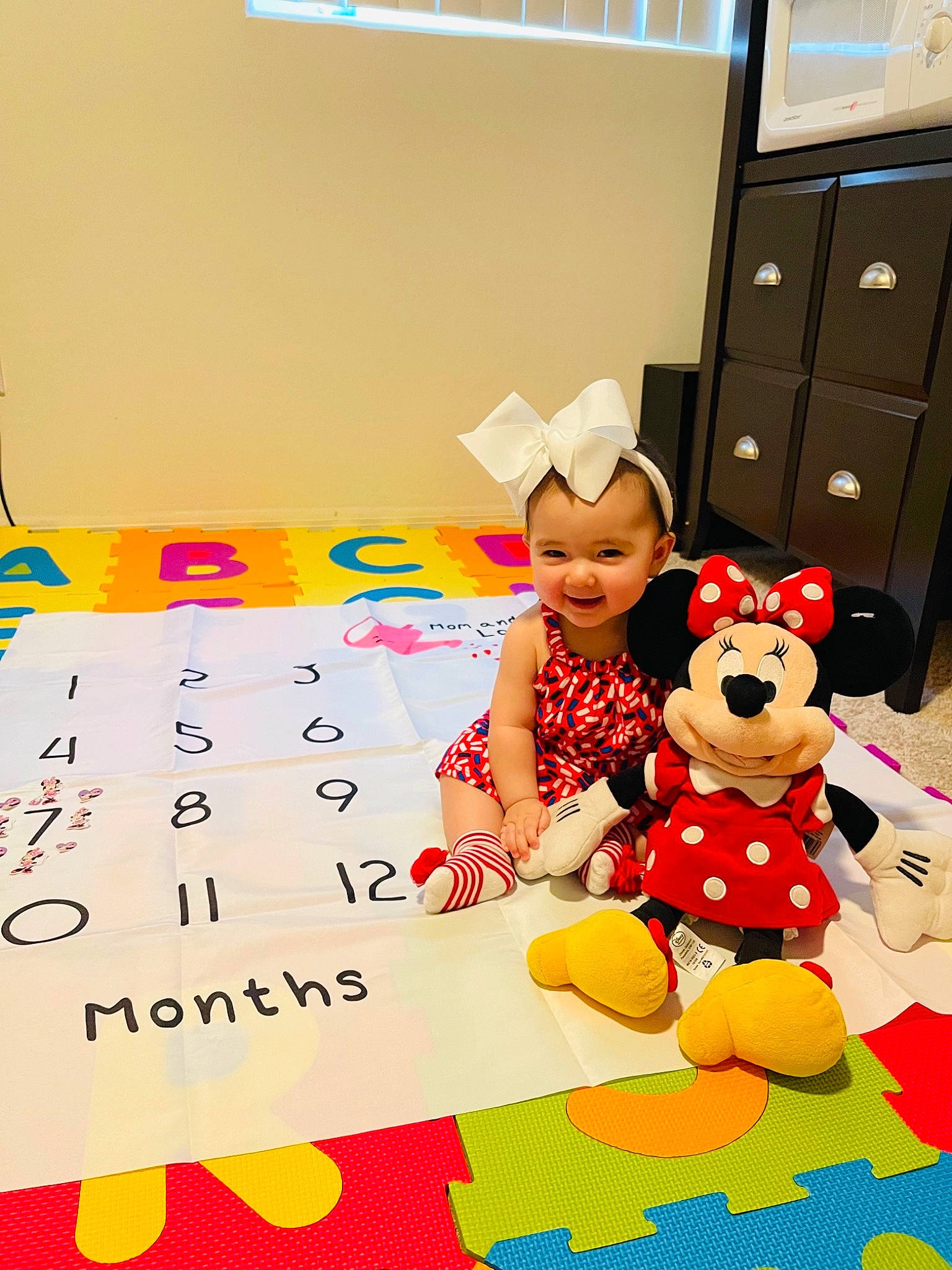 Kylie is registered to the contest to win money with this photo: art, baby, cabinetry, chest_of_drawers, child, drawer, event, fictional_character, flooring, font, fun, happy, joy, leisure, party_supply, pattern, person, play, recreation, smile