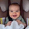 baby, smiling, infant, blanket, car_seat, child, happy, cute, portrait, face, safety_strap, clothing, indoor, cozy, young_child, soft_texture, head, skin, person, seat