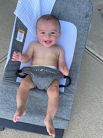 Caden is registered to the contest to win money with this photo: baby, baby_toddler_clothing, barechested, barefoot, chair, chest, child, flooring, foot, fun, grey, human_leg, joint, joy, pattern, person, product, rectangle, sitting, smile