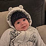 Jensen is registered to the contest to win money with this photo: baby, hoodie, hat, couch, smile, child, face, cozy, indoor, cute, apparel, polka_dot, ears, pillow, seated, infant, warm, clothing, portrait, expression