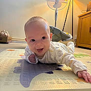 Jensen is registered to the contest to win money with this photo: baby, carpet, child, clothing, crawling, cute, face, fan, furniture, hand, happy, head, indoor, lamp, person, play_mat, room, smiling, toddler, wooden_cabinet