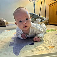 Jensen joined the competition — help win amazing prizes! baby, infant, play_mat, lying_down, indoor, face, curious, wide_eyes, clothing, carpet, fan, lamp, furniture, cabinet, floor, person, child, expression, cute, home