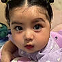 Rosa is registered to the contest to win money with this photo: baby, baby_girl, child, close_up, curious_eyes, cute, expression, face, hair_buns, hand, heart_pattern, indoor, infant, person, portrait, purple_clothing, skin, soft_lighting, toy, young_child