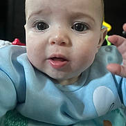 Hazel is registered to the contest to win money with this photo: baby, child, face, closeup, blue_clothing, hand, expression, curious, infant, young_child, skin, eyes, mouth, indoor, person, cute, apparel, sleeve, crab, fabric