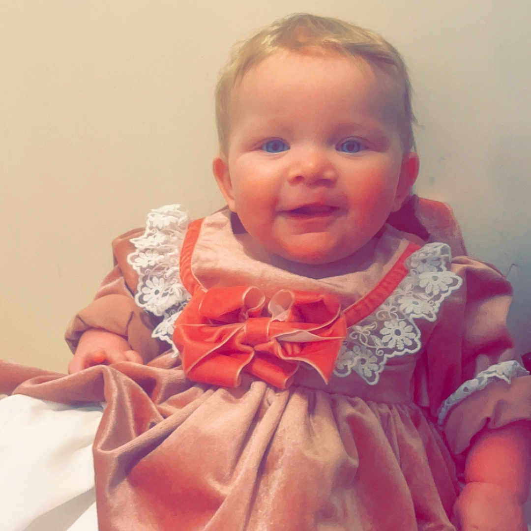 Emilie Louise joined the competition — help win amazing prizes! accessories, baby, blouse, clothing, costume, dress, face, fashion, formalwear, hat, head, jewelry, necklace, newborn, pants, person, photography, portrait, sitting, toy