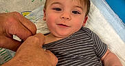 Thomas joined the competition — help win amazing prizes! baby, blue_background, care, child, cute, drawing, examination, face, hands, happy, head, indoor, infant, medical_table, paper, person, skin, smile, striped_clothing, toddler