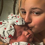 Waverly is registered to the contest to win money with this photo: adult, affection, baby, closeup, cute, face, family, headwrap, hello_kitty, indoor, kiss, love, mirror, newborn, patterned_clothing, person, skin, sleeping, tattoo, tender_moment