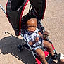 Omarius joined the competition — help win amazing prizes! toddler, child, stroller, ice_cream, chocolate, outdoor, sunlight, shadow, pavement, footwear, sandals, clothing, black_and_white, pattern, canopy, summer, person, baby, cute, snack