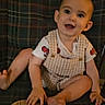 Raylan is registered to the contest to win money with this photo: baby, child, infant, plaid_chair, overalls, white_shirt, red_design, smiling, happy, sitting, wooden_plaque, months_marker, indoor, face, person, foot, hand, cute, young, portrait
