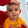 Raylan joined the competition — help win amazing prizes! baby, child, infant, person, hand, face, eyes, yellow_shirt, red_sleeve, indoor, portrait, cute, expression, holding, head, skin, human, clothing, closeup, love