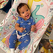 Naira is registered to the contest to win money with this photo: baby, infant, child, smiling, laughing, sitting, bouncer, blue_outfit, floral_pattern, white_socks, indoor, playroom, toys, second_child, family, portrait, happy, carpet, cartoon_animals, candid