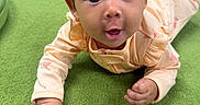 Naira joined the competition — help win amazing prizes! baby, infant, child, tummy_time, pointing, wide_eyed, surprised, curly_hair, smiling, portrait, indoor, playroom, carpet, play_equipment, pink_clothing, long_sleeves, floor, close_up, sitting, family