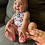 Emerson is registered to the contest to win money with this photo: baby, child, infant, bow, headband, couch, gray, clothing, hand, foot, toes, smile, happy, cute, skin, sitting, indoors, person, face, playful
