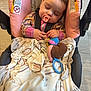 baby, car_seat, pacifier, blanket, toy, sleeping, child, indoor, infant, clothing, plush_toy, comfort, peaceful, cute, hands, floor, fabric, seat_belt, toddler, rest