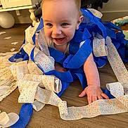 Liam is registered to the contest to win money with this photo: baby, child, smiling, birthday, streamers, blue, crawling, floor, home, celebration, happy, cute, infant, decorations, party, person, young, face, playful, fun