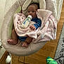 Hunter is registered to the contest to win money with this photo: baby, bottle, blanket, blue_clothing, baby_rocker, floor, footwear, green_sock, hand, head, infant, indoor, leg, person, plush, resting, sitting, soft_toy, wood_floor, young_child