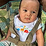 baby, child, seat, safety_strap, clothing, patterned_fabric, animal_print, white_shirt, infant, cute, face, eyes, arm, hand, closeup, indoor, photography, person, young, serious
