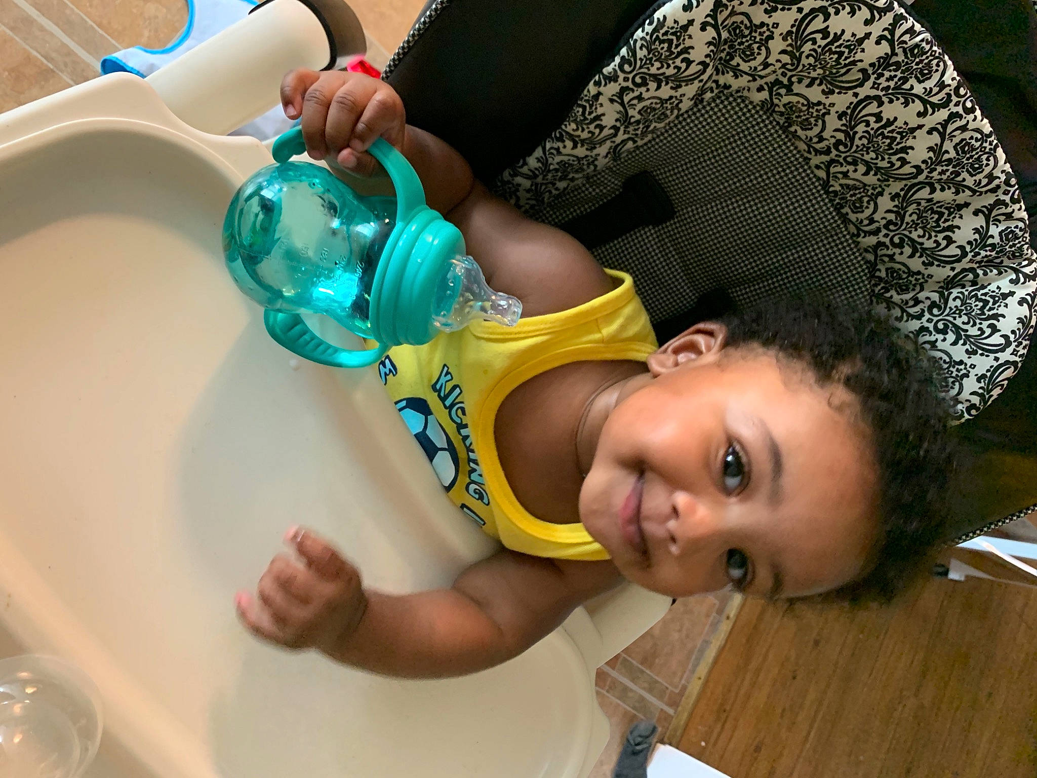 Kyro is registered to the contest to win money with this photo: afro, baby, baby_products, baby_toddler_clothing, chair, child, cooking, drinkware, fun, hand, happy, joy, leisure, person, plastic, plastic_bottle, room, smile, sun_hat, tableware