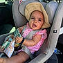 Lyna participe au concours pour gagner de l'argent avec cette photo : baby, child, car_seat, straw_hat, pink_dress, toy, car_interior, seatbelt, infant, sitting, window, sunlight, face, expression, hand, foot, safety, vehicle, headrest, clothing