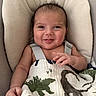 baby, infant, smile, face, blanket, dinosaur, cushion, seat, happy, cute, child, portrait, clothing, hand, skin, young, indoors, expression, comfort, cozy
