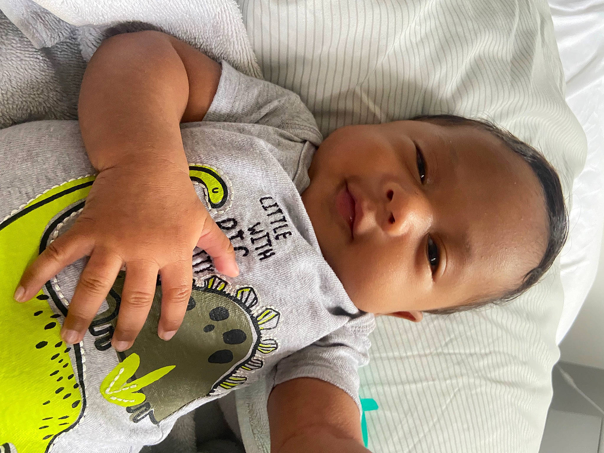 Kareem is registered to the contest to win money with this photo: baby, baby_products, baby_toddler_clothing, cheek, child, comfort, elbow, eye, happy, human, human_leg, linens, mouth, person, product, room, skin, sleeve, t_shirt, thigh